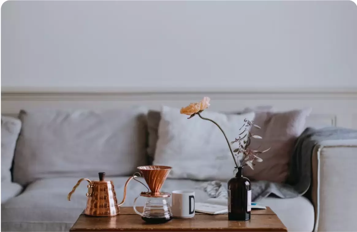 A coffee pot and cup on a table.