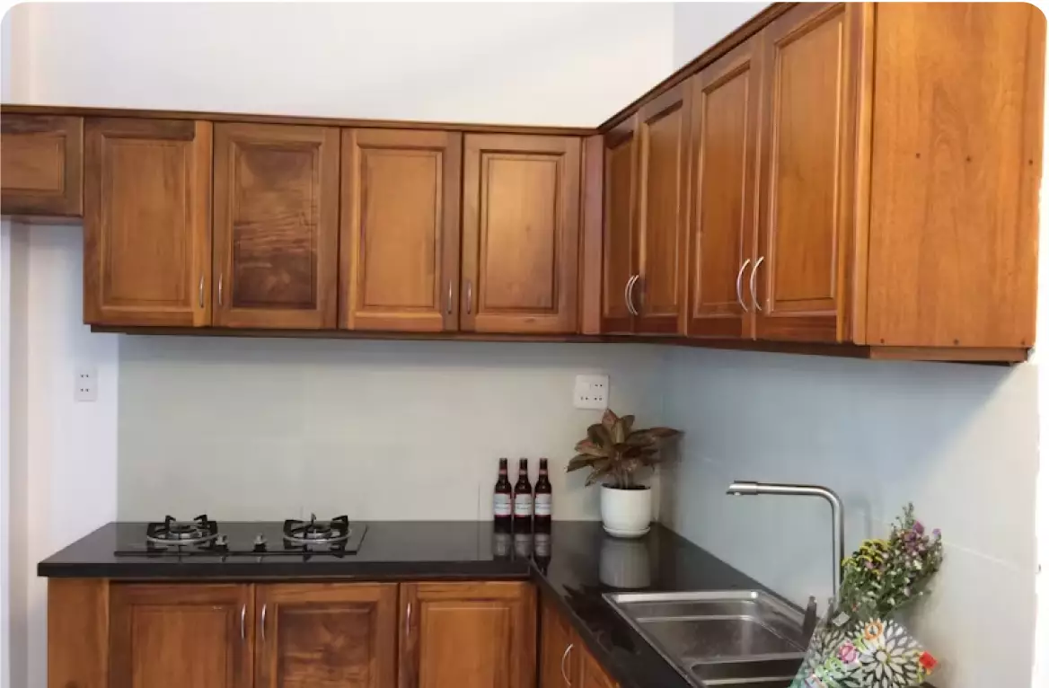 A kitchen with wooden cabinets and black counter tops.