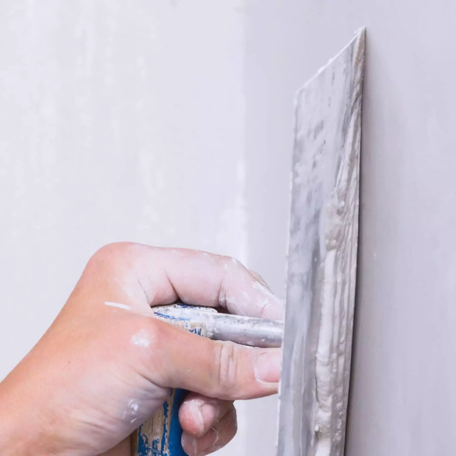 A person is using a knife to cut the wall.